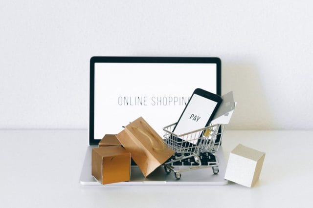 a miniature shopping cart on macbook laptop, mobile app shopify